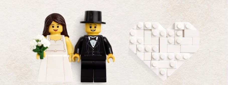 Noivinhos de LEGO de mãos dadas ao lado de um coração de peças brancas